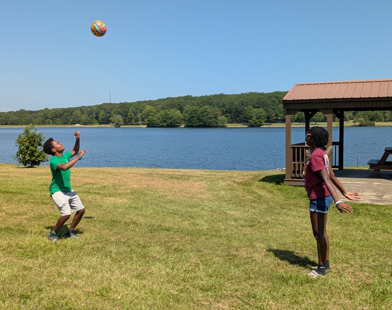 Volleyball in the air between two oldest kids