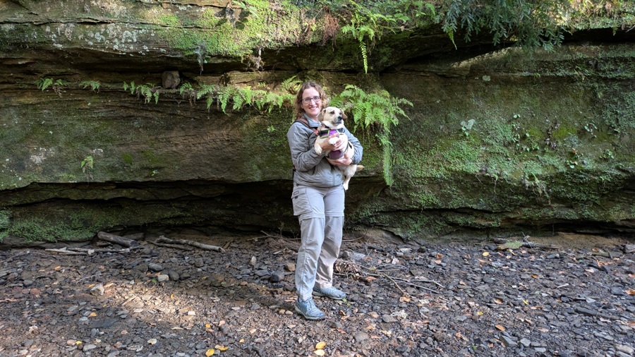 Norma holding Daphne with rock wall behind