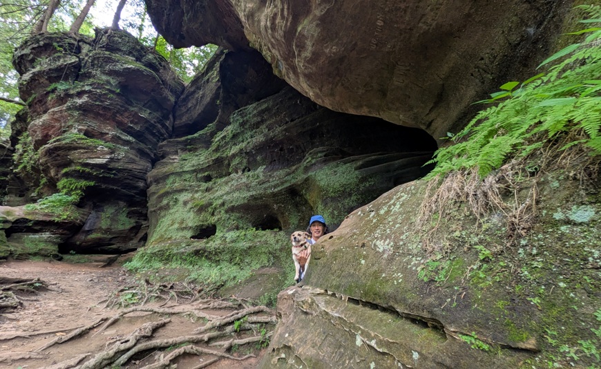 Me holding Daphne with lots of greenery growing on the rocks