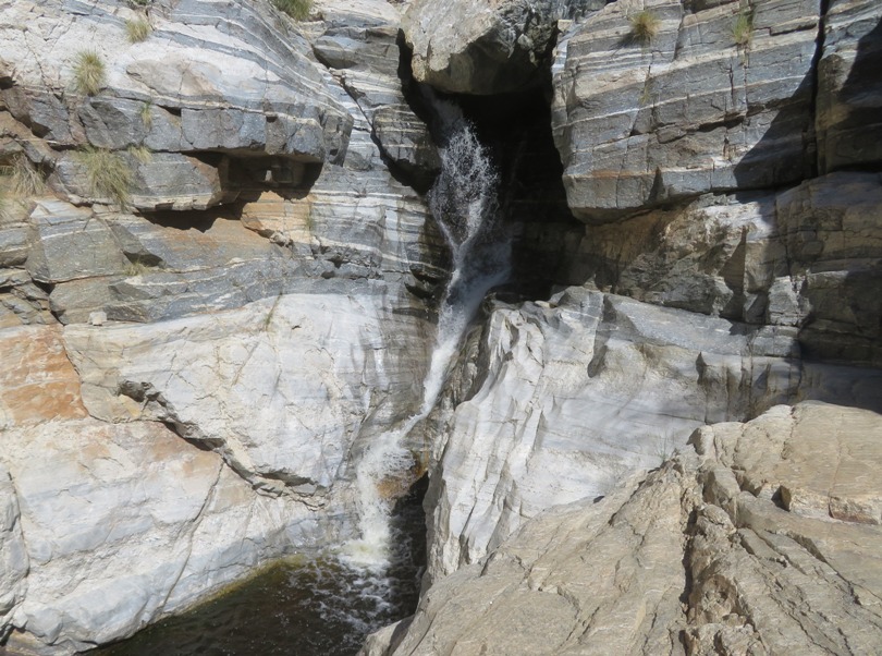Close-up of waterfall lined by gray striated boulders