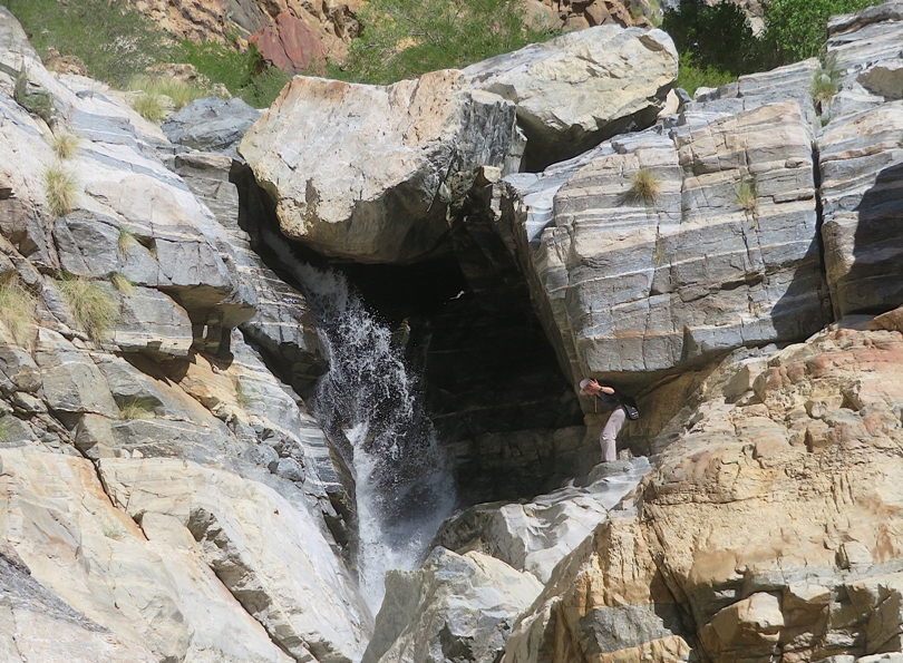 Norma waving next to waterfall
