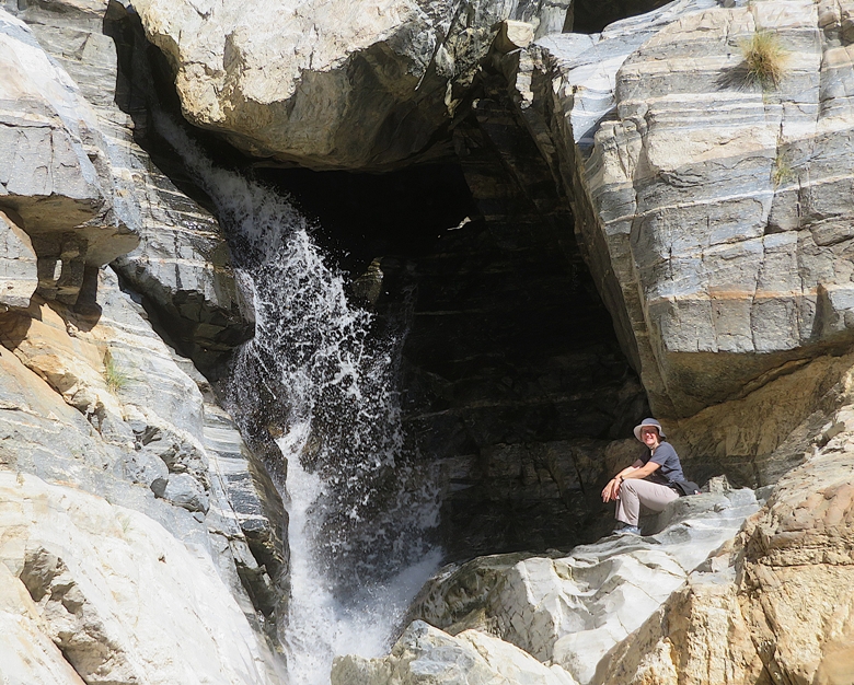 Norma seated next to waterfall