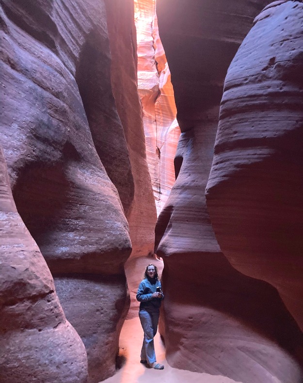 Norma standing in narrow, shadowy area