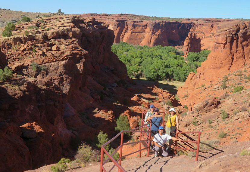 Group shot in in front of shallow canyon with trees near the bottom