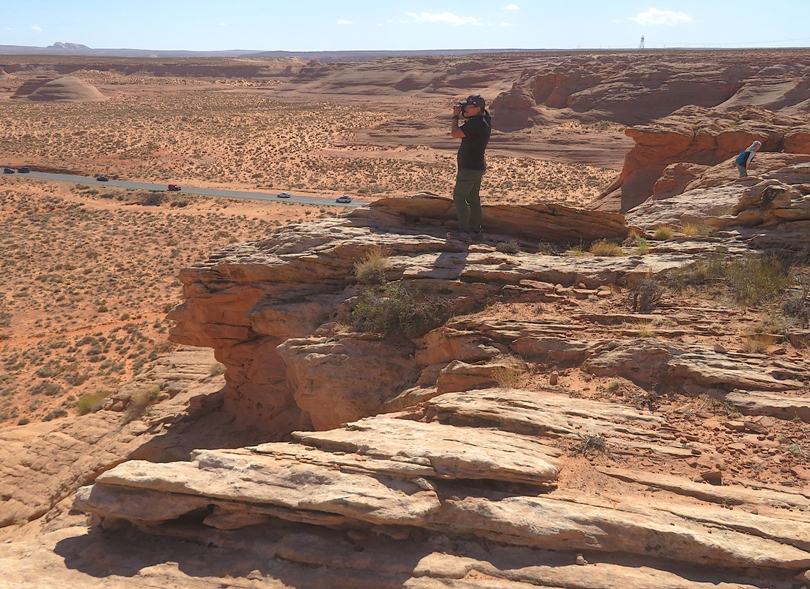 Robin taking a photo while standing on jagged rocks
