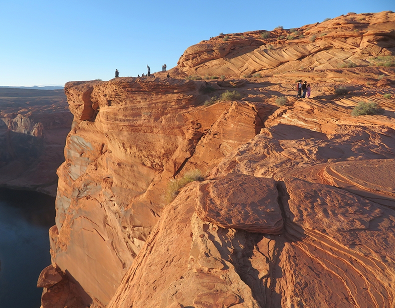 People standing at the top of a steep cliff