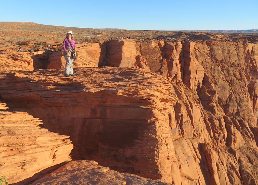 Norma standing on well-lit rocks