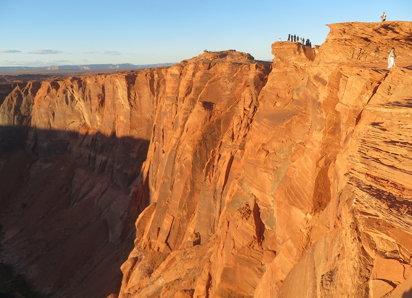 Couple in wedding attire standing at the edge of the cliff