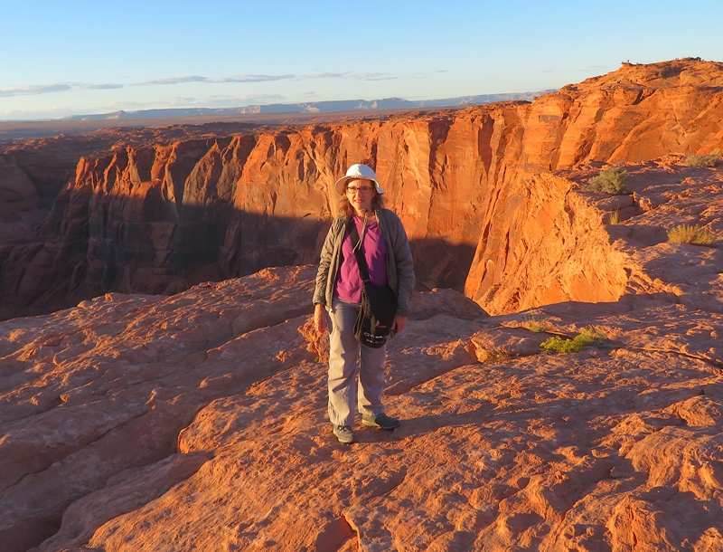 Norma standing with both sunny and shady cliff walls behind