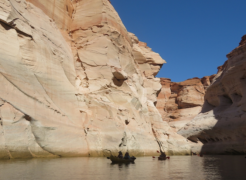 Two kayaks in the shadow of the canyon with the walls lit