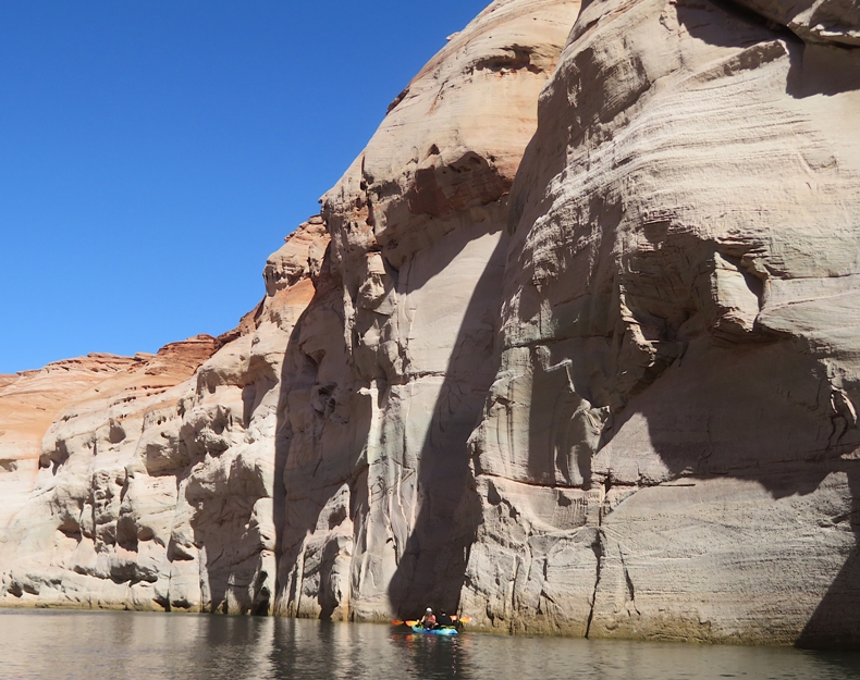 Kayak dwarfed by high canyon wall