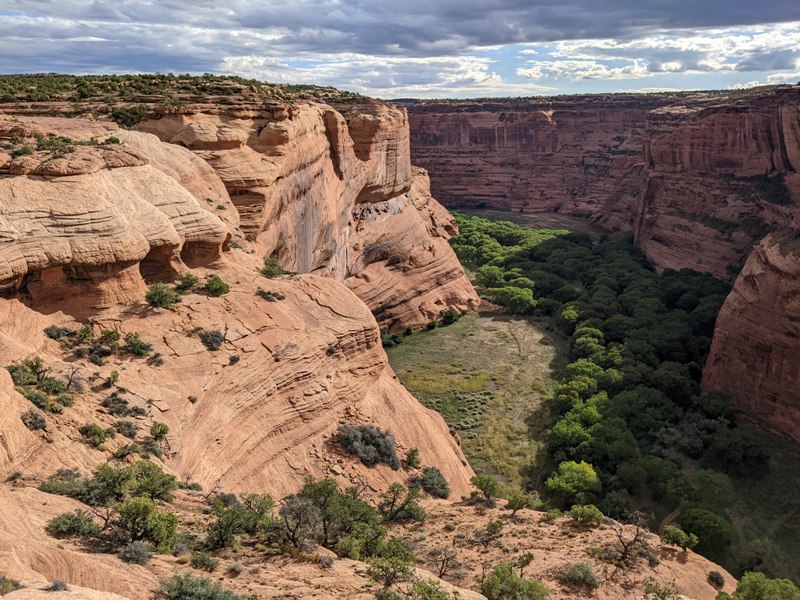 Dark clouds over an illuminated canyon wall