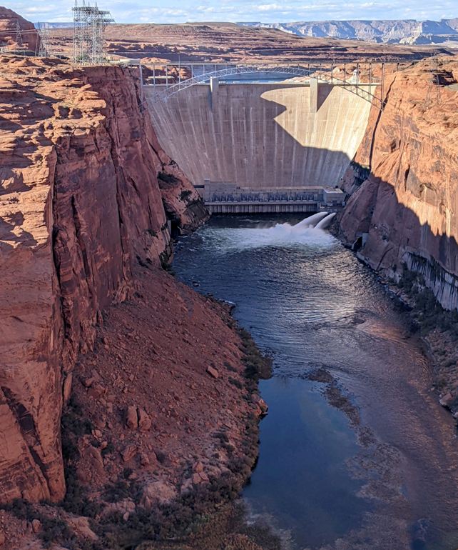 Zoomed-out view of the dam showing water flowing downstream