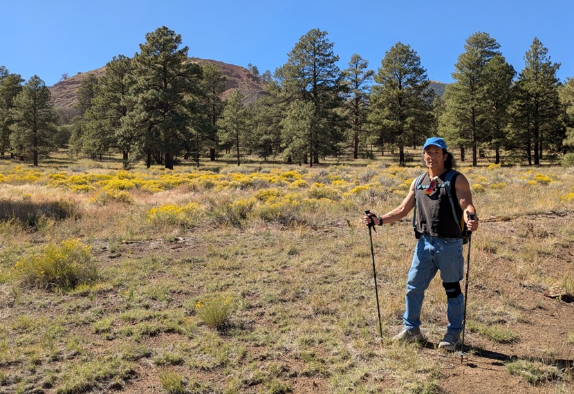 Me with yellow flowers and green trees behind