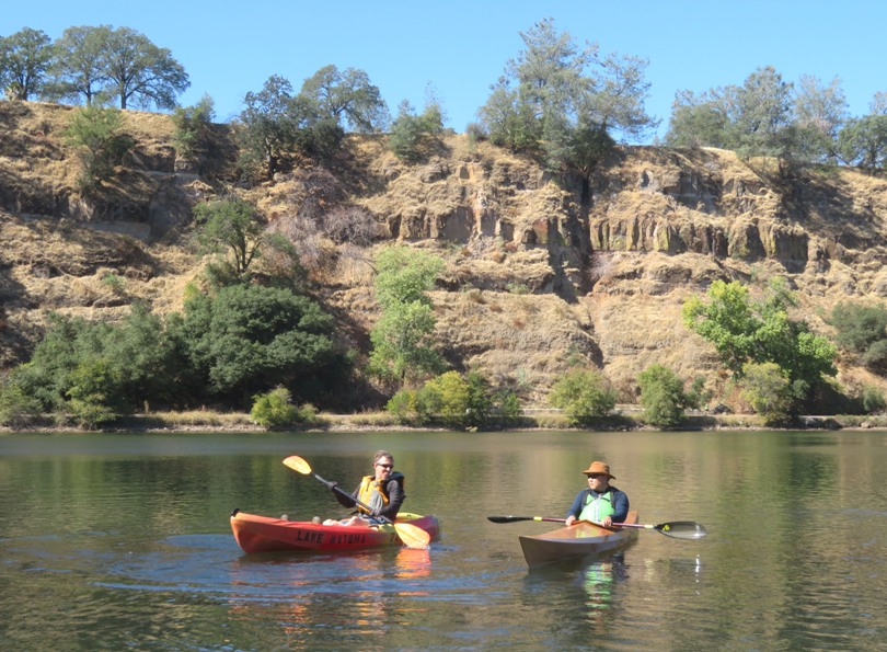 Ken and Steve in their kayaks with cliff behind