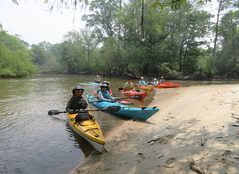 Kayakers in their boats on the beach