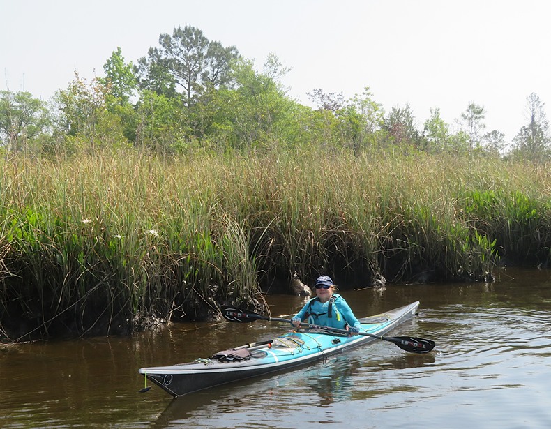 Linda on kayak in front of bay grasses