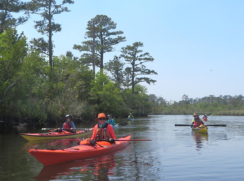 Lori in her kayak with other kayakers behind