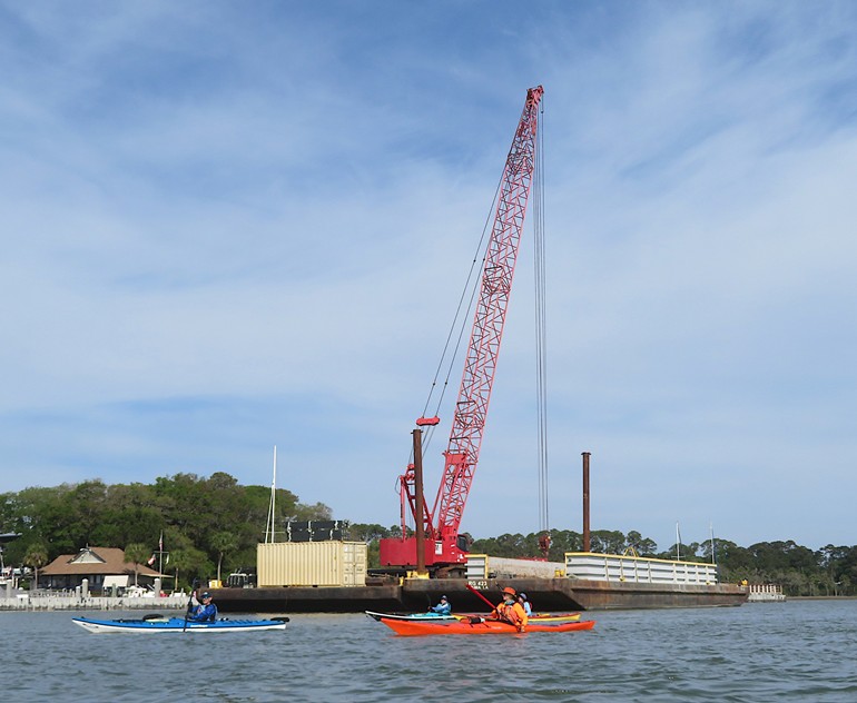Kayakers passing crane
