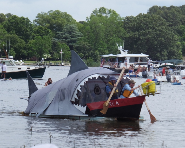 Front view of boat resembling shark chasing small boat
