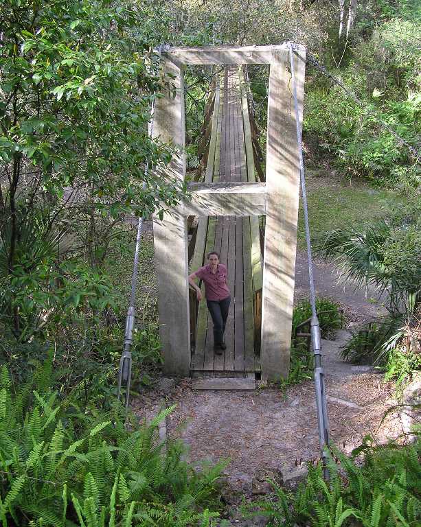 Norma standing in front of bridge with ferns before her