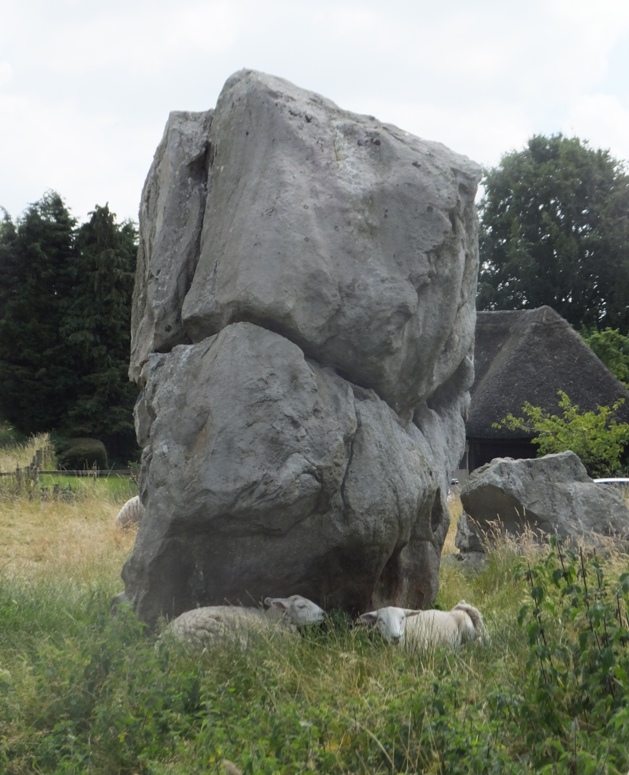 Sheep resting by giant stone