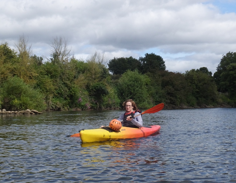 Norma with helmet on her kayak