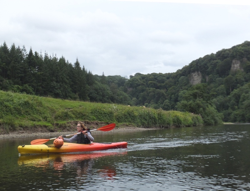 Norma kayaking with Coldwell Rocks in the distance