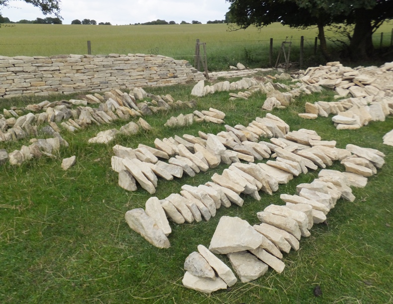 Stones on the ground to be used to build a fence