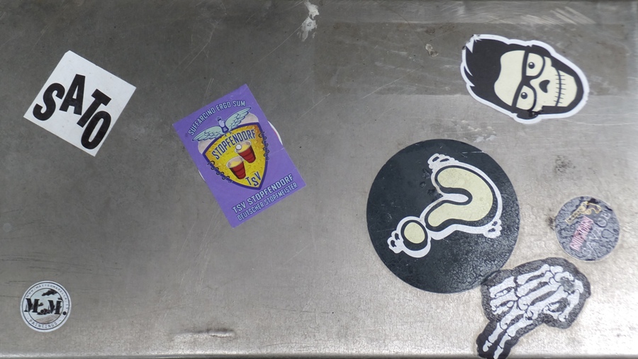 Stickers on utility box with SATO appearing in the upper left