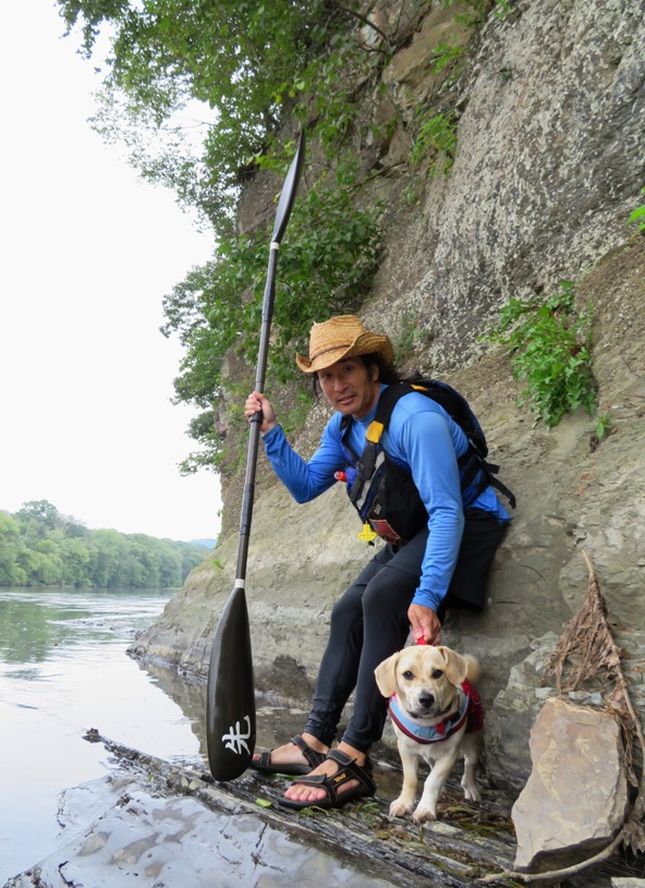 Daphne and I standing next to a rocky outcrop with me holding my kayak paddle