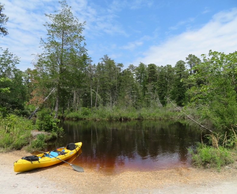 Kayak on beach next to dark water