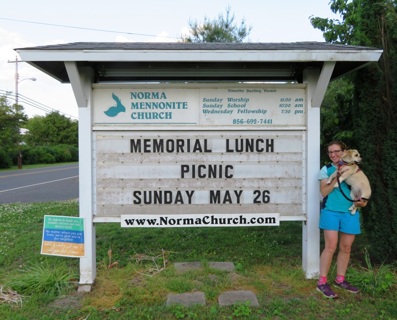 Norma and Daphne standing next to sign for Norma Mennonite Church