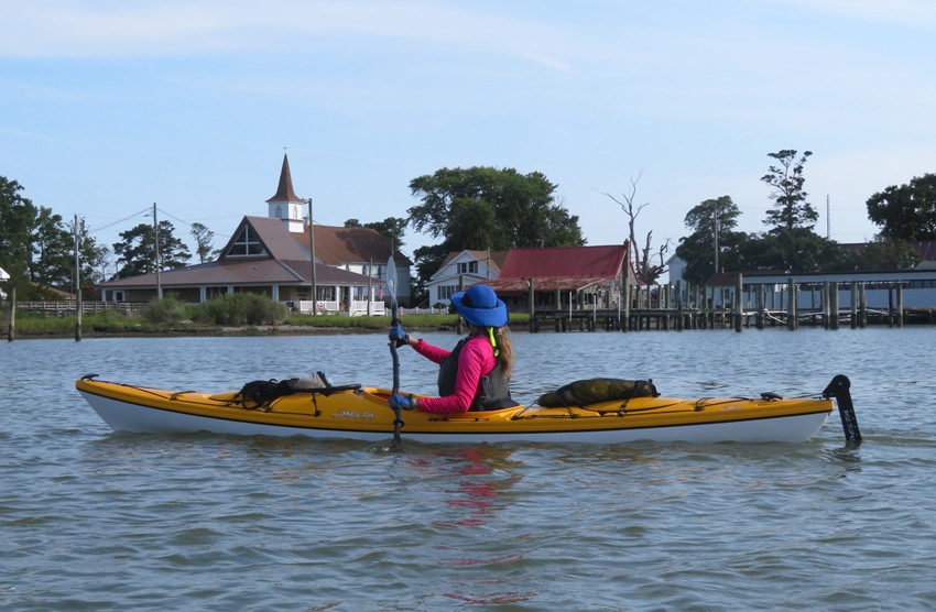 Kayaker in yellow boat looking at church