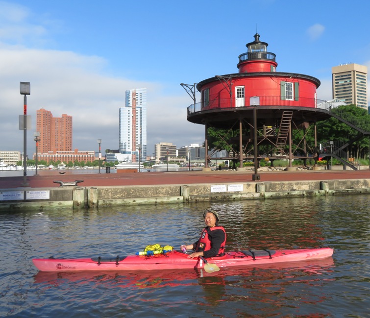 Steve in red kayk with the lighthouse behind