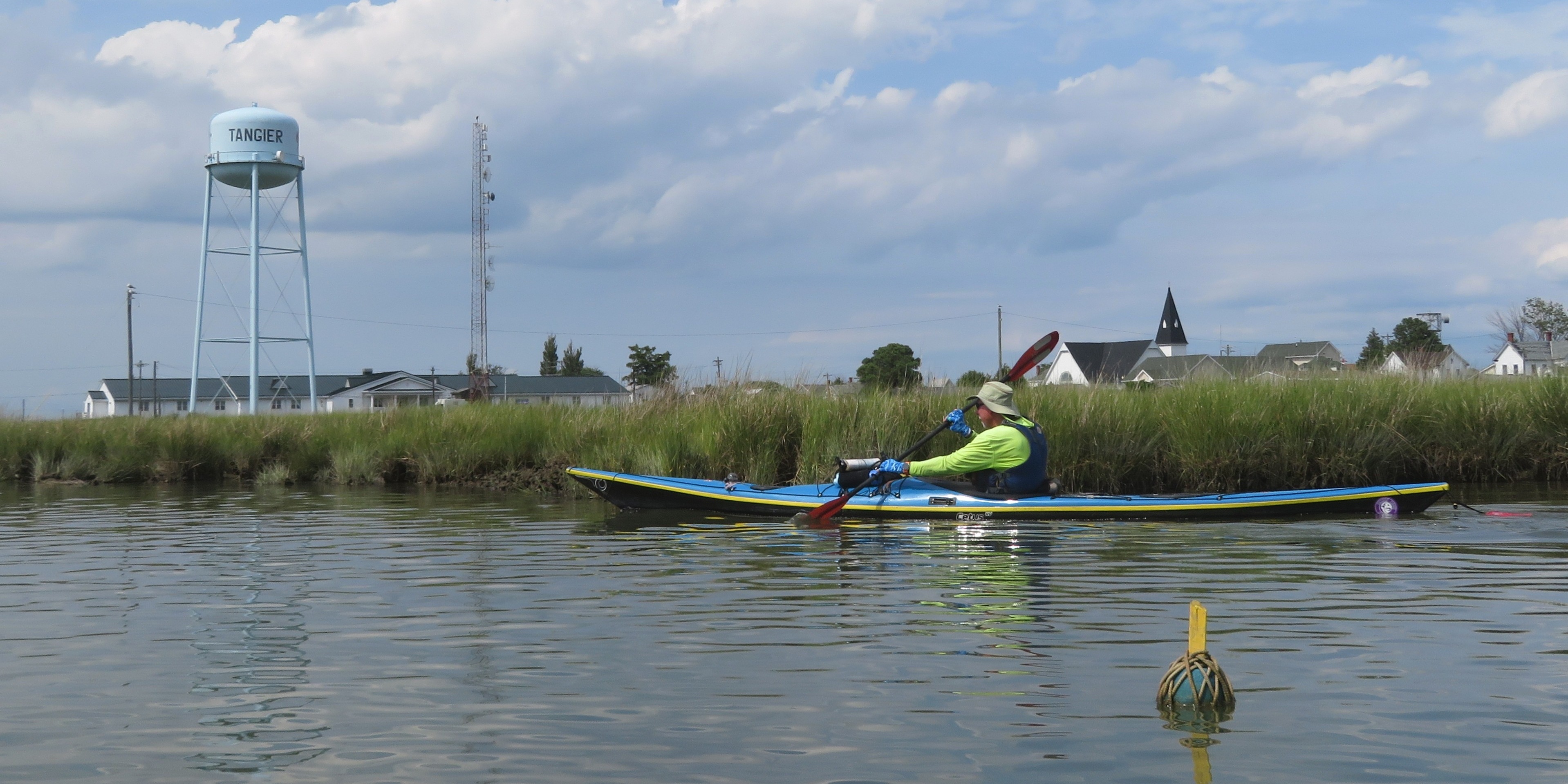 Dr. Greg kayaking with church and watertower in background
