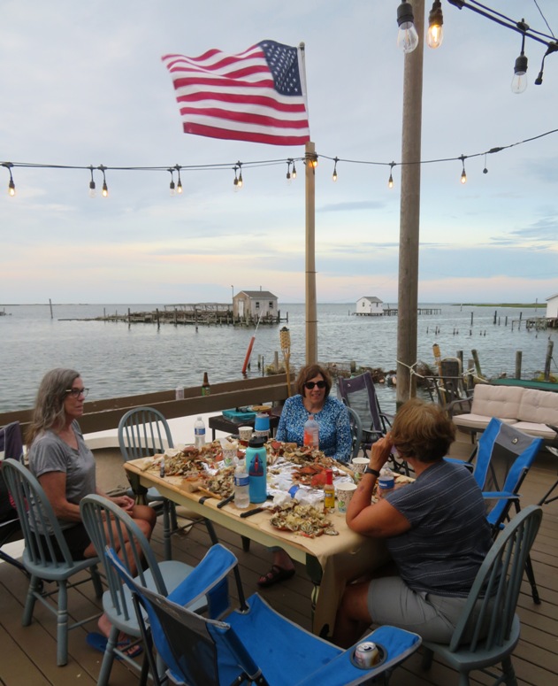 Lisa, Jennifer, and Diana at crab feast with American flag flying