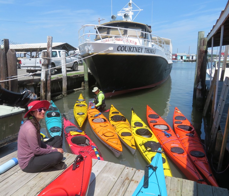 Dr. Greg positioning boats with Anisa sitting on the pier
