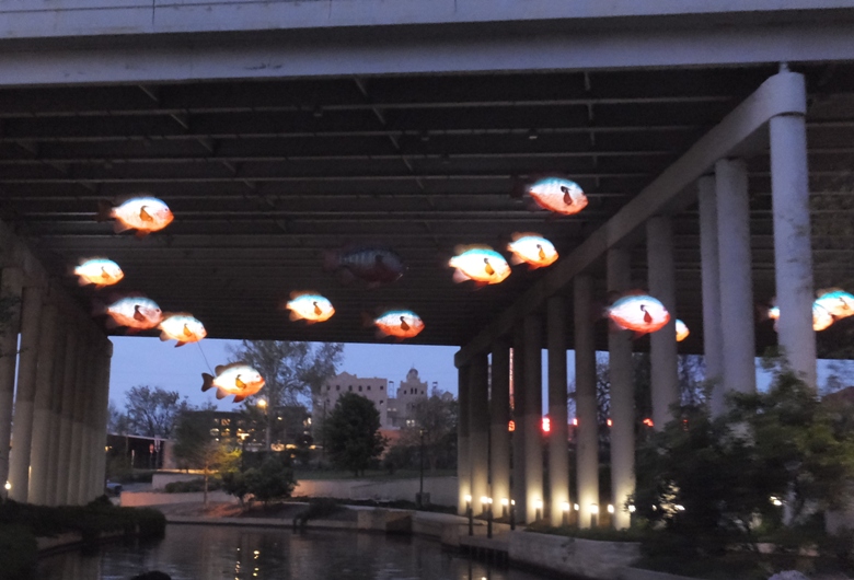 Glowing art fish hanging from bridge