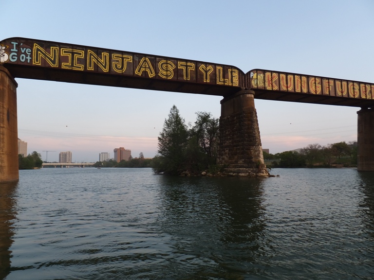 Graffiti on railroad bridge that says 'Ninja style kung fu grip'