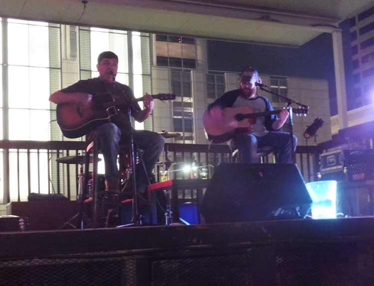 Two guitarists playing on a rooftop