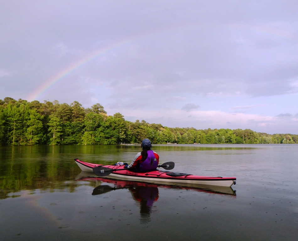 Aht in her kayak, looking at rainbow