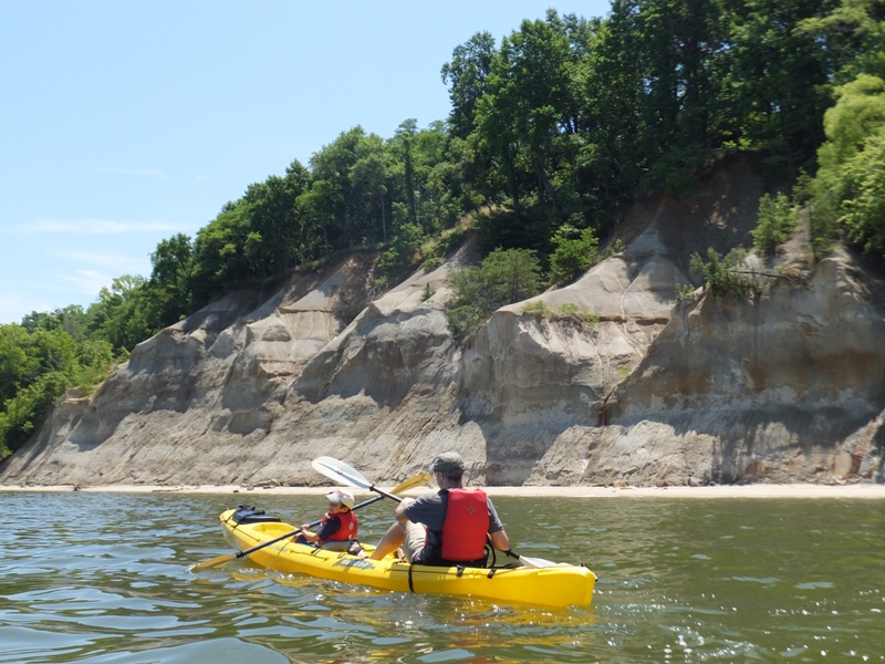 Harald and his youngest son in a tandem kayak with Horsehead Cliffs behind