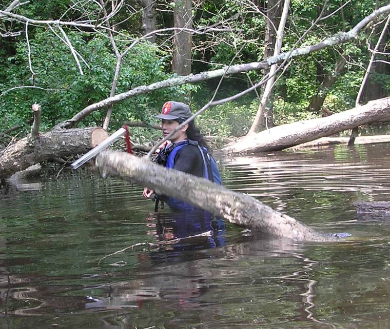 Me sawing through fallen tree while standing in the water