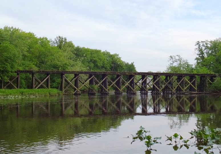 Old wooden railroad bridge above the water