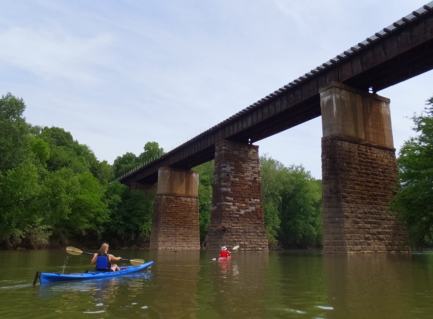 Francisca kayaking towards old railroad bridge