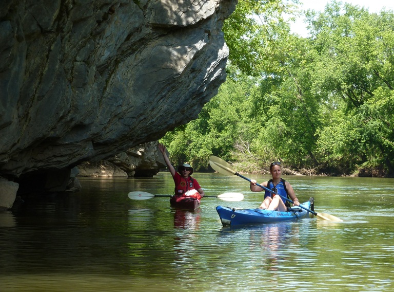 A close-up of Alex and Francisca kayaking near a boulder