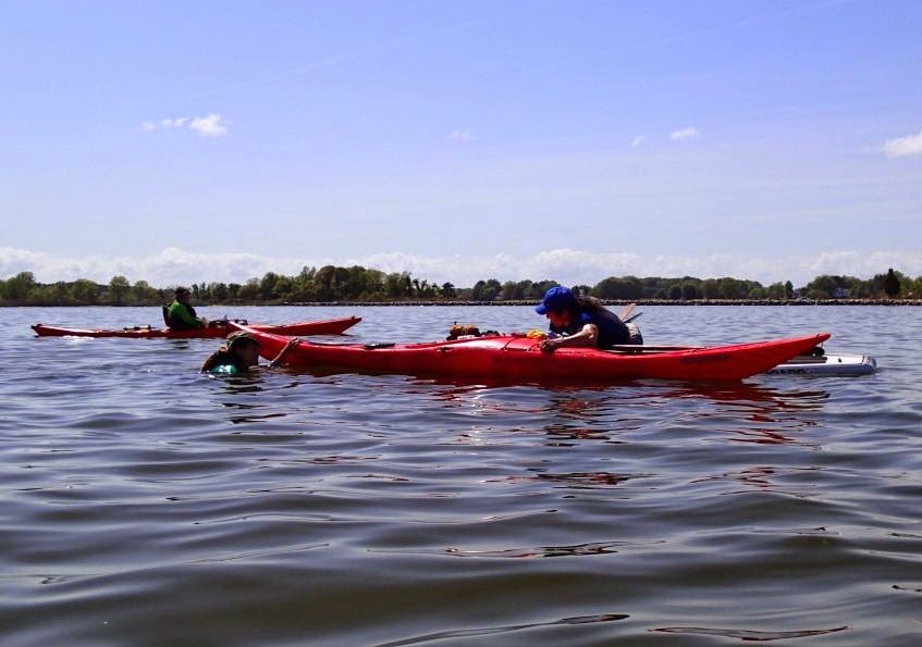 Me steadying Renee's kayak from my SUP while she gets back in