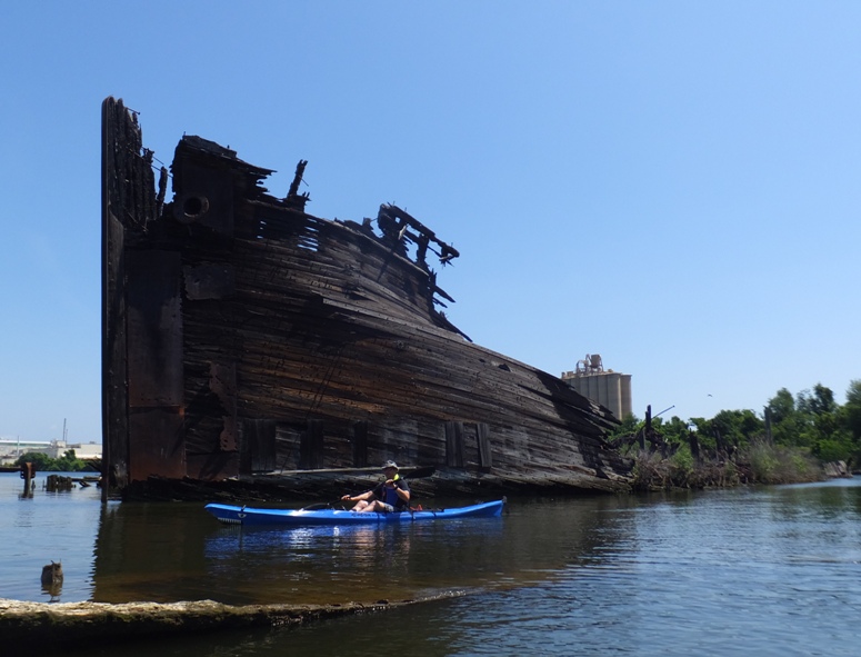 Jimmy kayaking in front of a wreck near Walnut Point