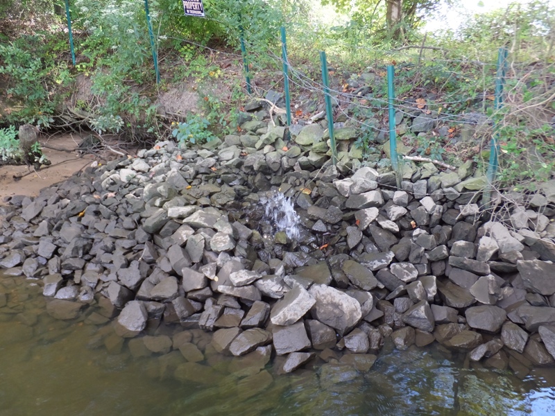 Water shooting out from pile of rocks